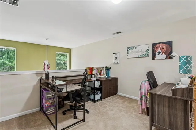 a view of a workspace with furniture and a window