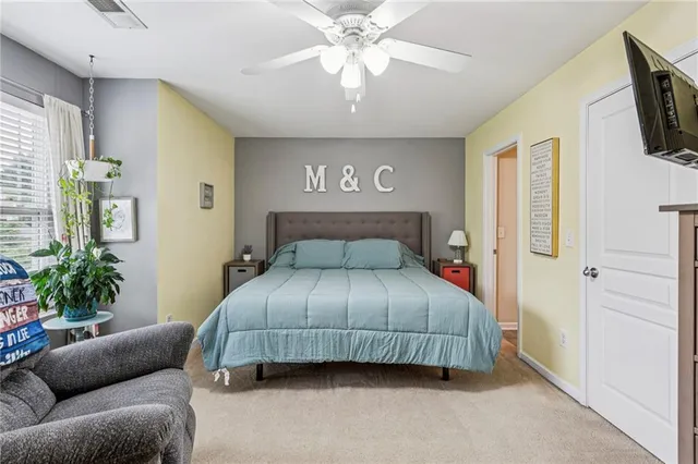 a bedroom with a bed a couch and a flat screen tv