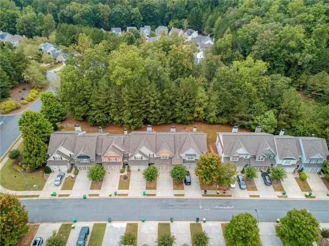 an aerial view of a house with a yard and a large tree