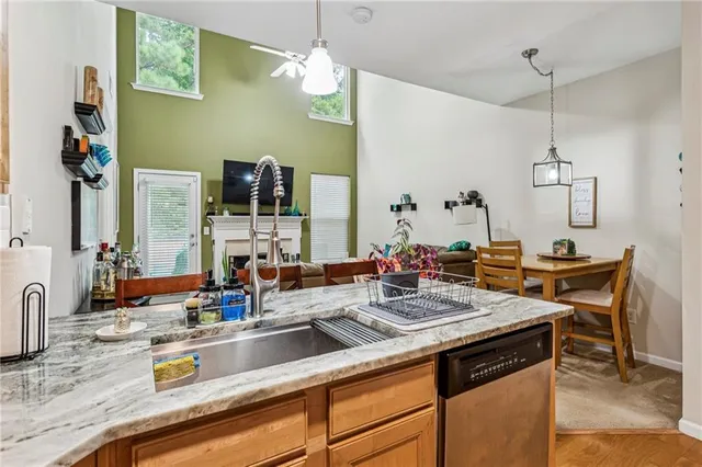 a view of a kitchen island a sink wooden floor and living room view