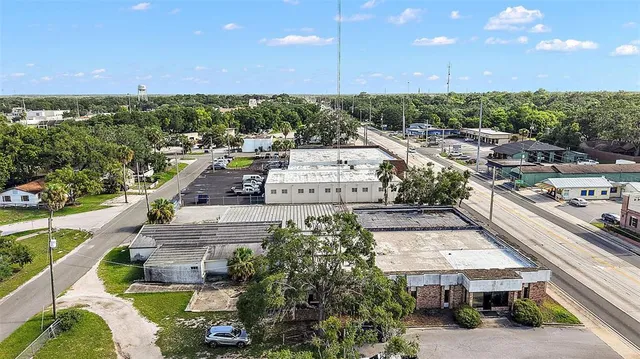 an aerial view of residential houses with outdoor space and trees
