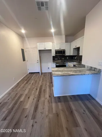 a kitchen with stainless steel appliances granite countertop a sink a stove top oven a counter space and cabinets