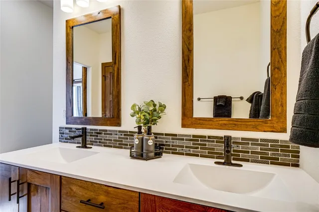 a bathroom with a sink a toilet a mirror and shower