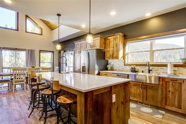 a kitchen with kitchen island granite countertop a sink a counter top space appliances and cabinets