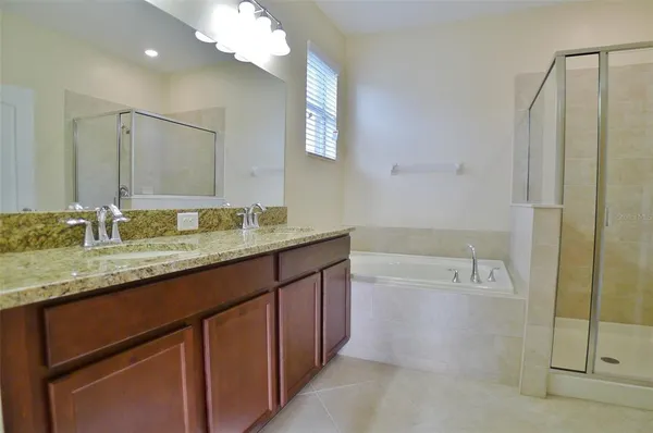 a bathroom with a granite countertop sink a mirror and a bathtub
