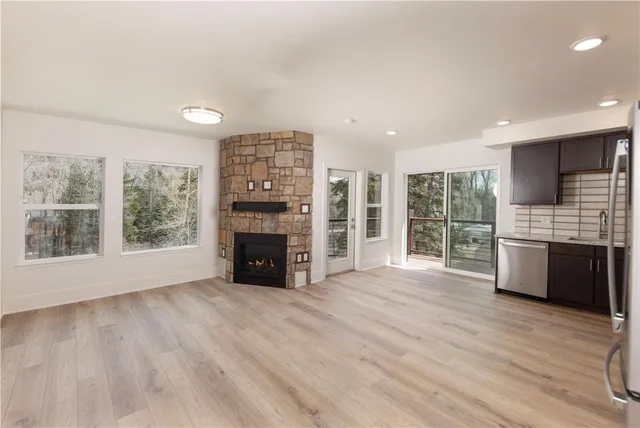 a view of an empty room with a window and fire place