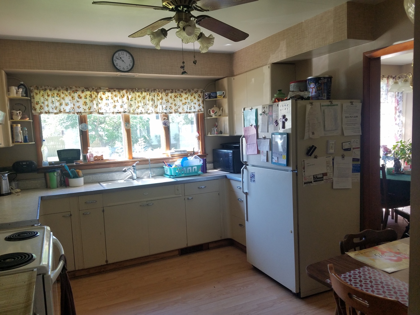 1015 6th Avenue Rochelle, IL 61068 - Photo 5 of 13 a kitchen with granite countertop a refrigerator a sink dishwasher a dining table and chairs with wooden floor