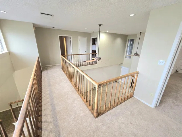 a view of a hallway with wooden floor and stairs