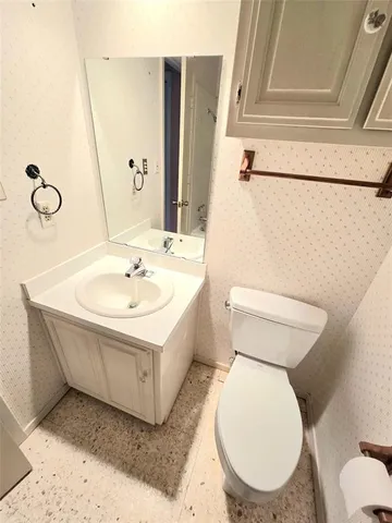 a white toilet sitting next to a bathroom sink