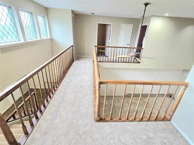 a view of staircase with railing and a window