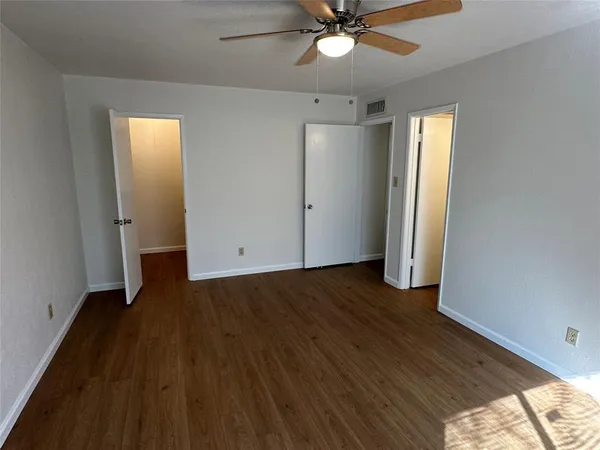 an empty room with wooden floor and closet