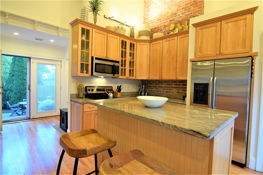 26 Phelps Road Middletown, RI 02842 - Photo 6 of 27 Granite and stainless compliment the wood cabinets and exposed brick.