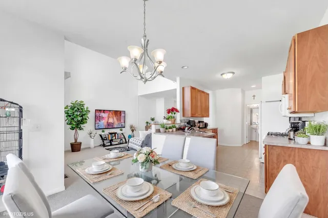 a view of a dining room with furniture a chandelier and wooden floor