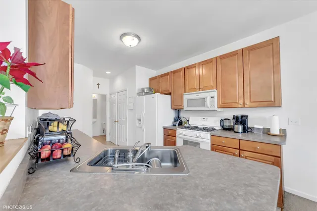a kitchen with granite countertop a sink cabinets and appliances