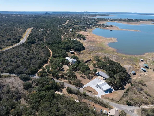 an aerial view of ocean and residential houses with outdoor space
