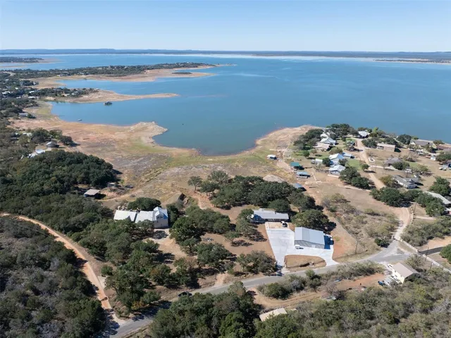an aerial view of ocean and residential houses with outdoor space
