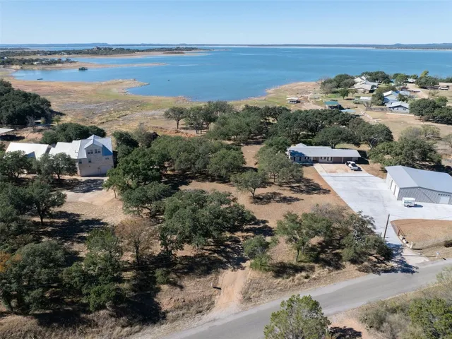 an aerial view of residential houses with outdoor space and trees