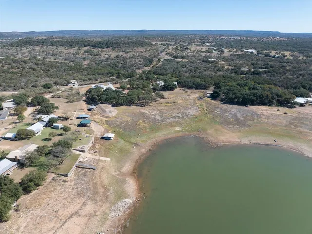 a view of dirt yard with large trees