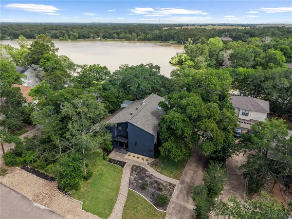 an aerial view of house with yard and lake view