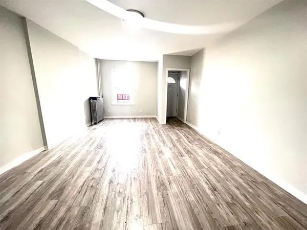 a view of a room with wooden floor and a sink