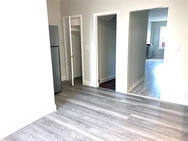 a view of a room with a hallway and wooden floor
