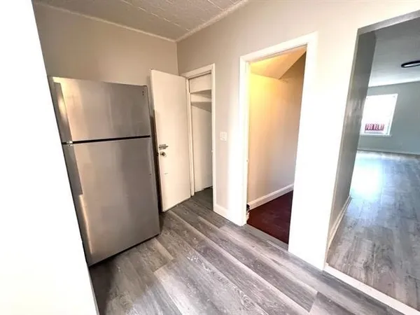 a view of a kitchen with refrigerator and wooden floor