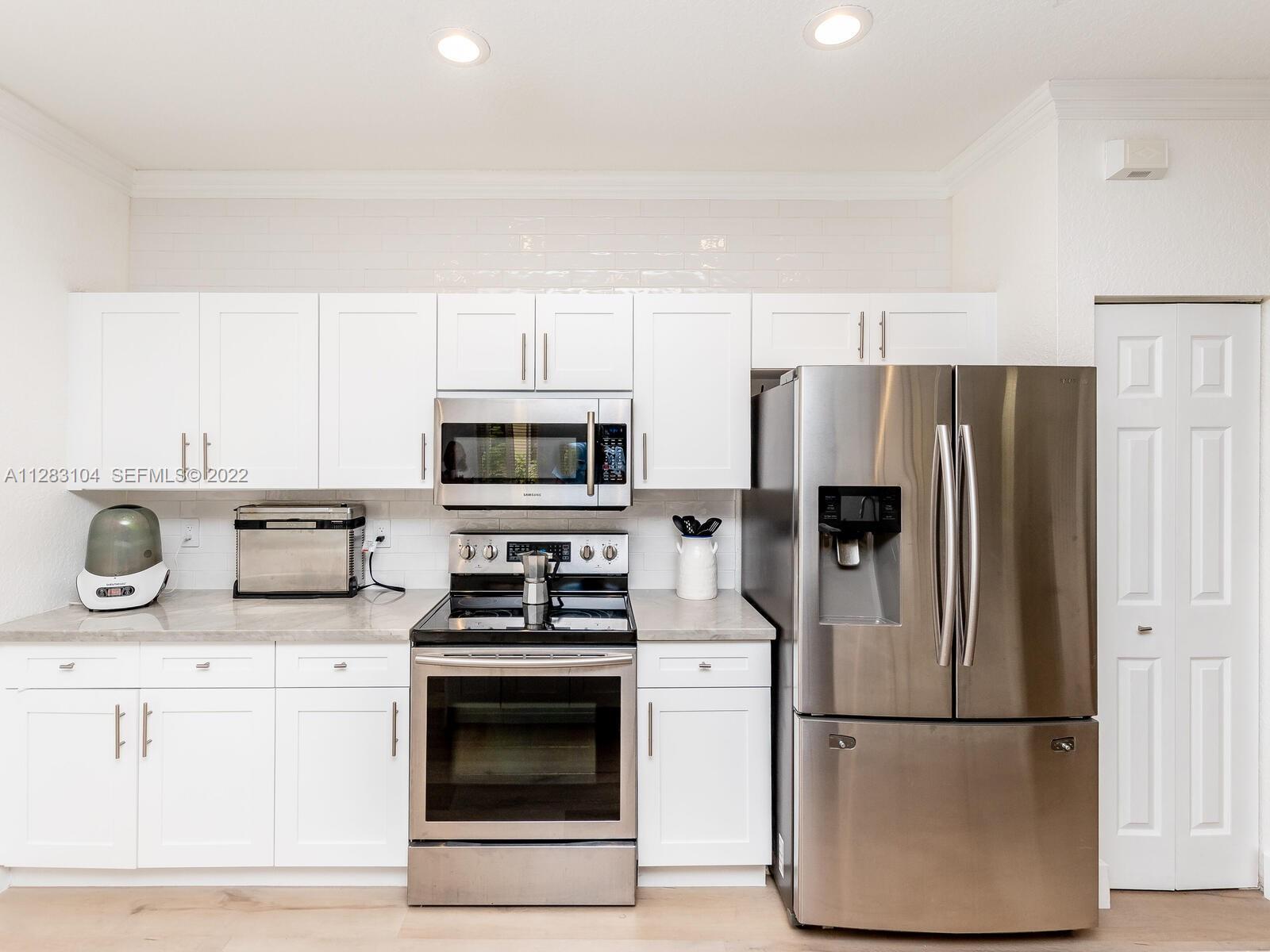 471 Fishtail Terrace Weston, FL 33327 - Photo 4 of 64 a kitchen with stainless steel appliances a refrigerator stove and microwave