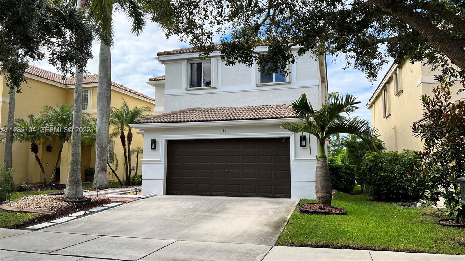 471 Fishtail Terrace Weston, FL 33327 - Photo 44 of 64 a front view of a house with a yard and garage