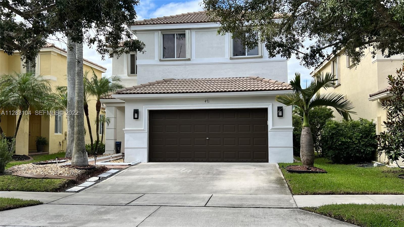 471 Fishtail Terrace Weston, FL 33327 - Photo 57 of 64 a front view of a house with a yard and garage
