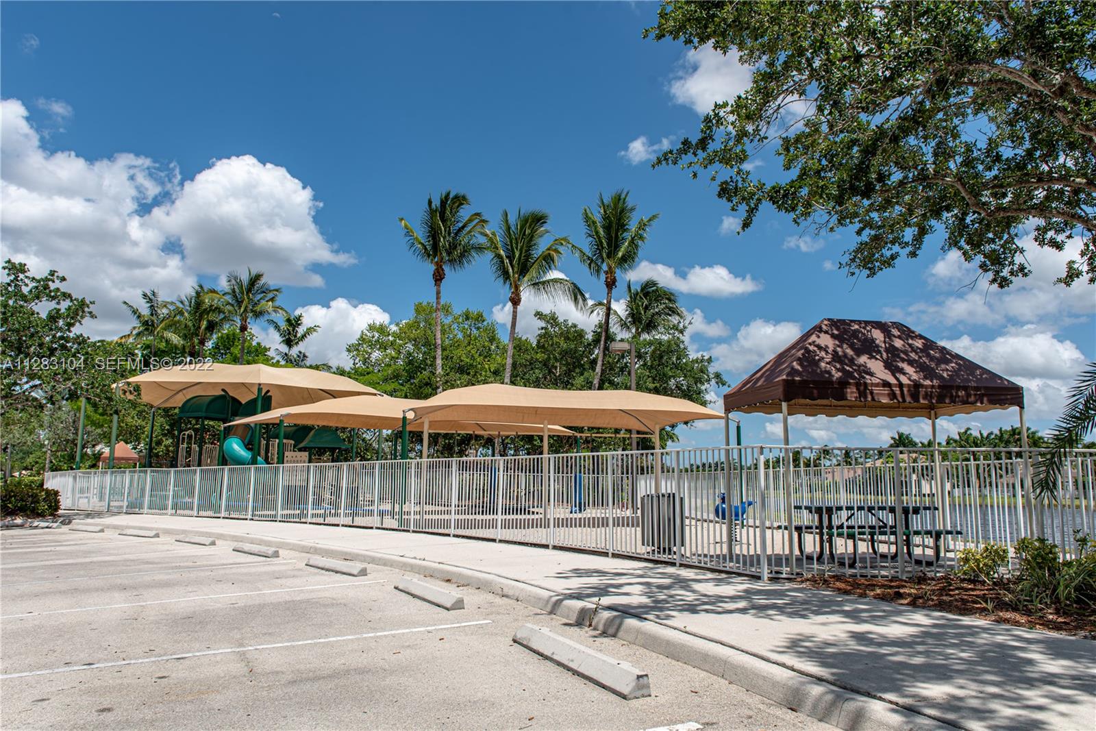 471 Fishtail Terrace Weston, FL 33327 - Photo 61 of 64 a patio with a table and chairs under an umbrella with a barbeque