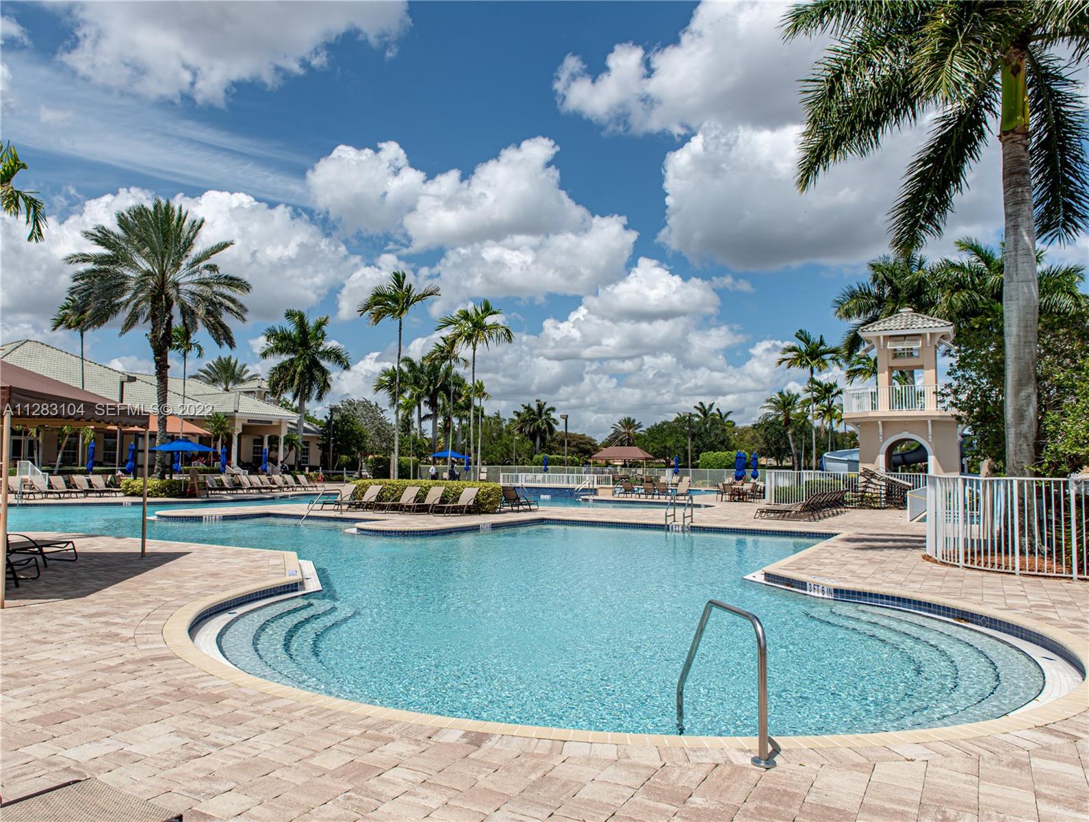471 Fishtail Terrace Weston, FL 33327 - Photo 63 of 64 a view of a swimming pool with lawn chairs potted plants and palm trees