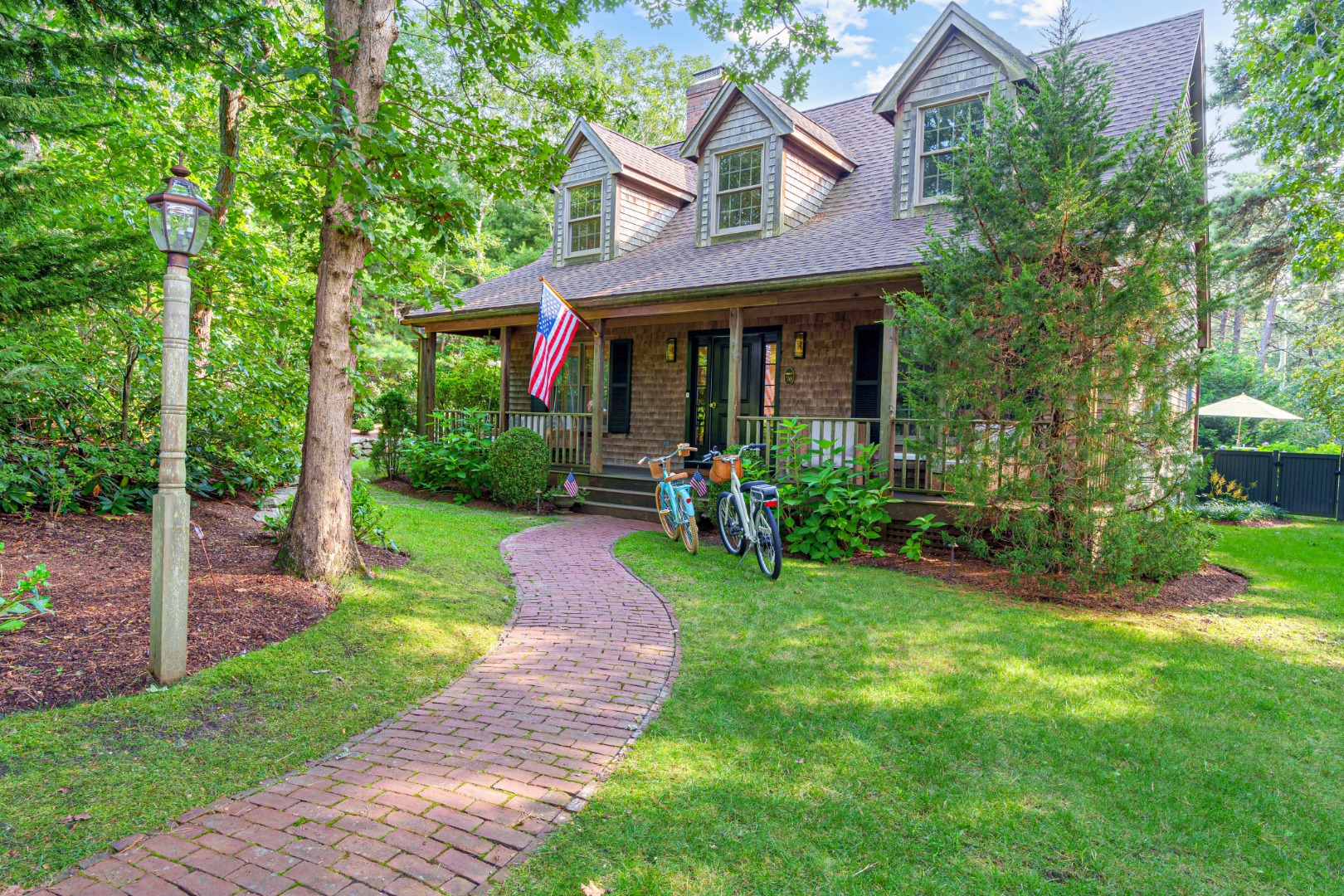 70 Marthas Road Edgartown, MA 02539 - Photo 2 of 54 a front view of a house with a yard table and chairs