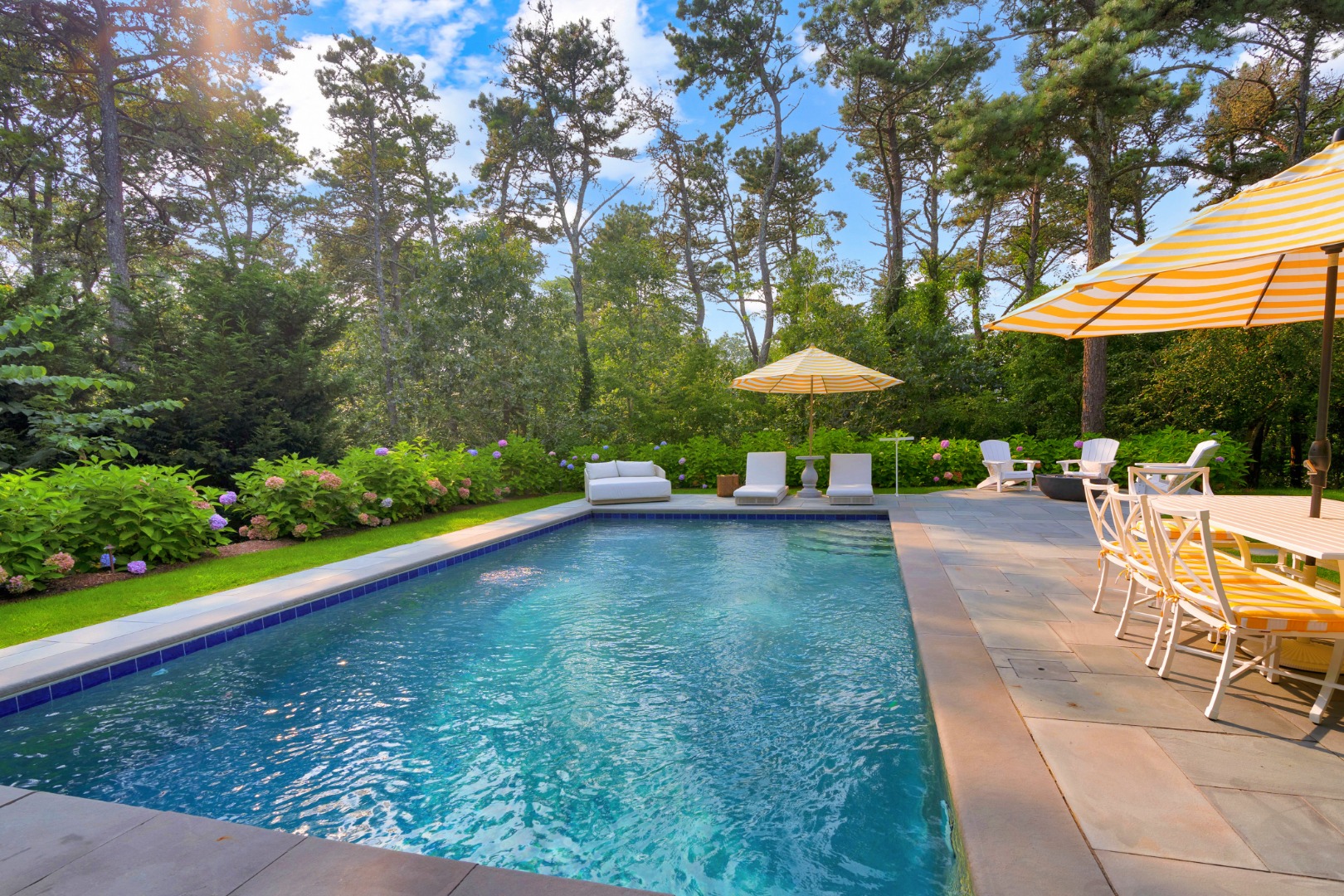 70 Marthas Road Edgartown, MA 02539 - Photo 48 of 54 a view of a swimming pool with a table and chairs under an umbrella