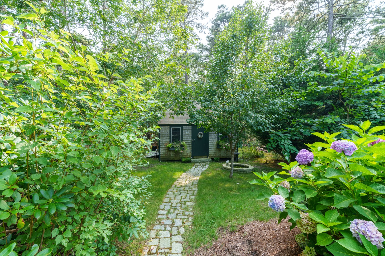 70 Marthas Road Edgartown, MA 02539 - Photo 53 of 54 a view of a garden with plants and a fountain