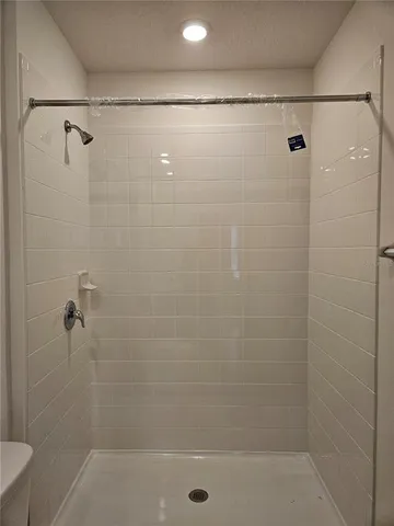 a bathroom with a granite countertop sink toilet a mirror and shower