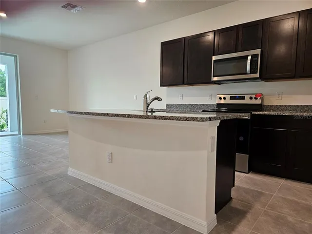 a kitchen with stainless steel appliances granite countertop a sink stove and microwave