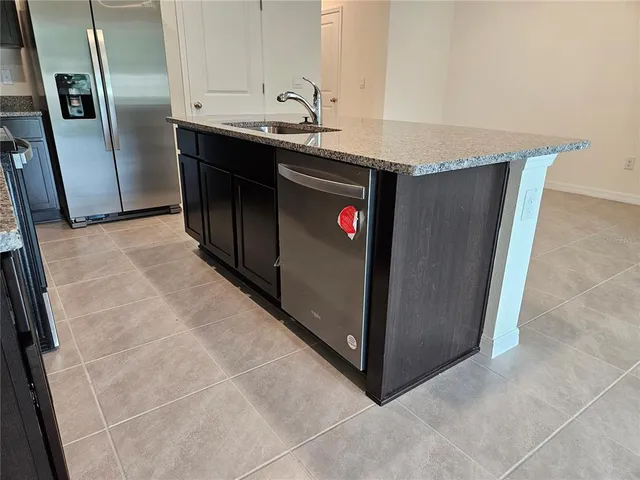 a kitchen with stainless steel appliances a sink stove and refrigerator