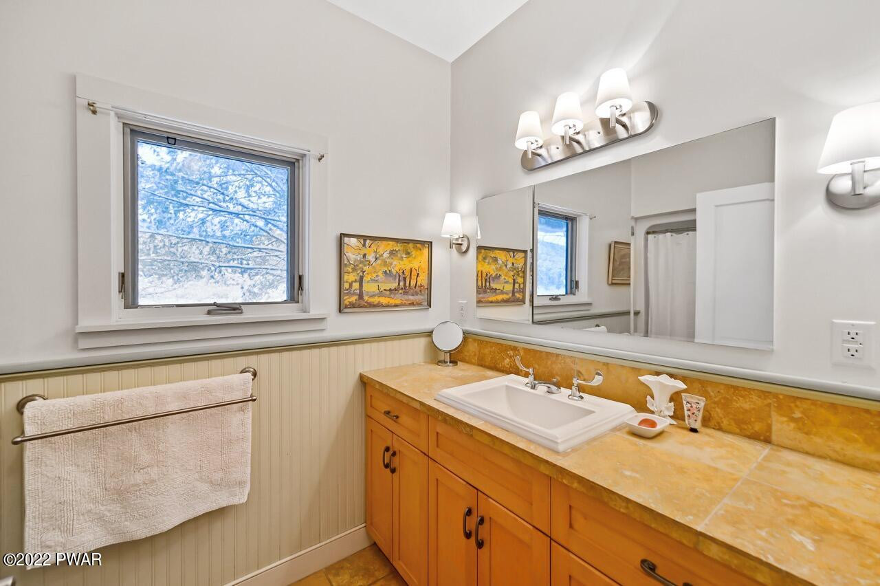 45 Tammany Flats Road Damascus, PA 18415 - Photo 46 of 73 a bathroom with a sink a large mirror and a window