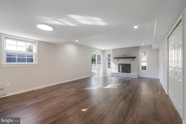 an empty room with wooden floor and a window