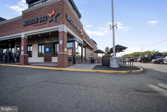 a view of a cafe with a couple of cars parked in front of it