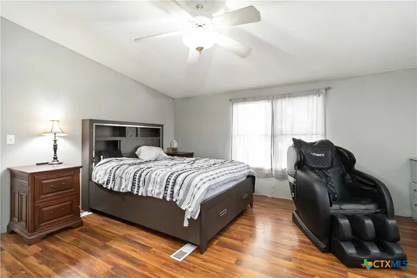 a bedroom with a bed wooden floor and a chandelier