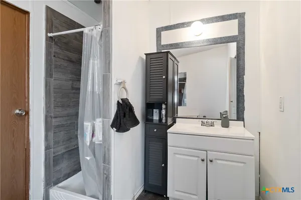 a bathroom with a sink vanity and mirror