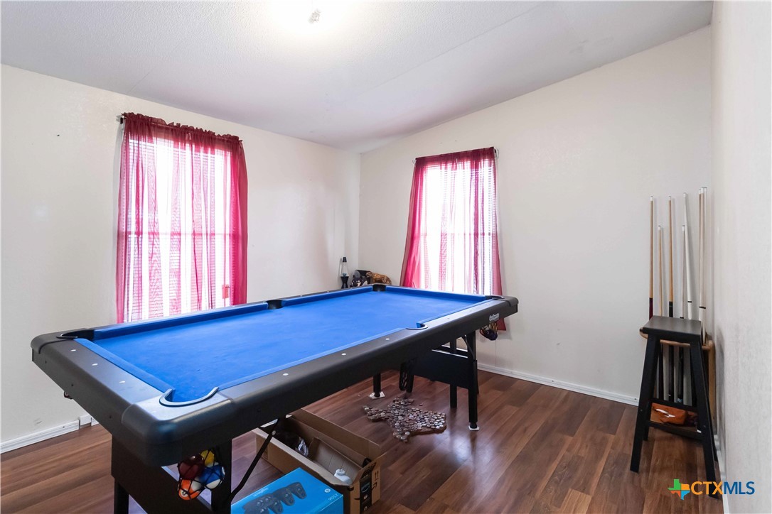 182 Pintail Loop San Marcos, TX 78666 - Photo 23 of 26 a room with pool table two windows and a wooden floor