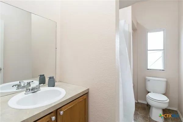 a bathroom with a sink toilet and a mirror