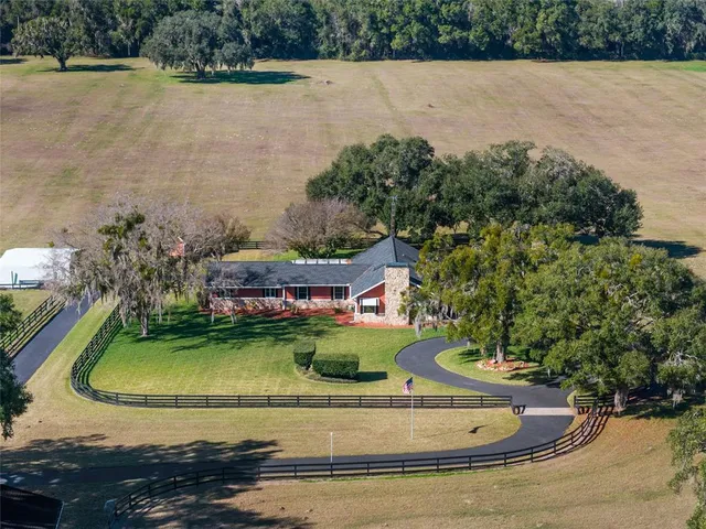 an aerial view of a house with yard swimming pool and outdoor seating