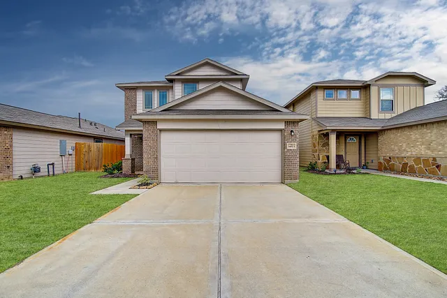 a front view of a house with a yard and garage