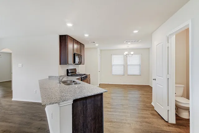 a kitchen with granite countertop a sink and cabinets