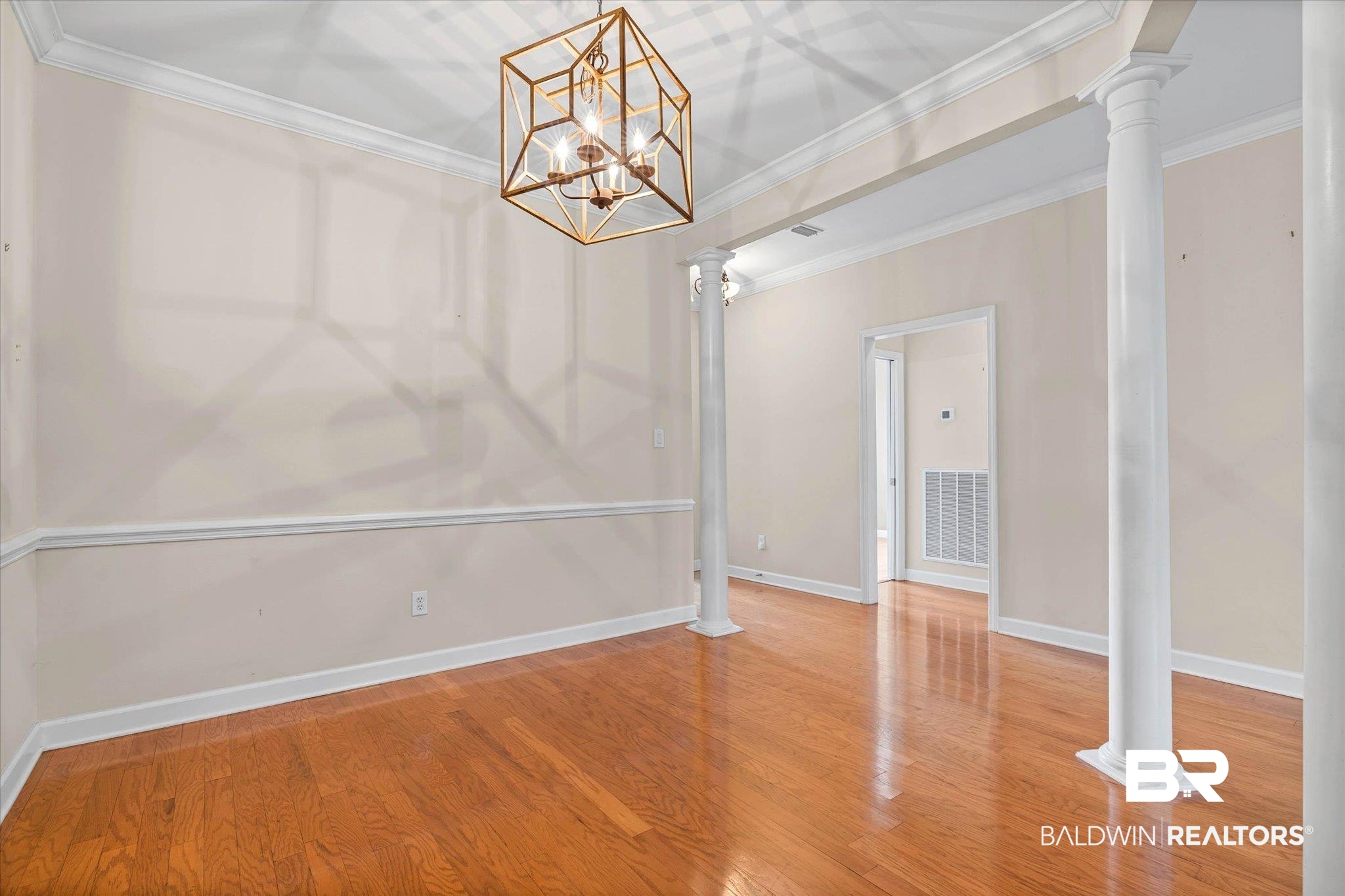 1003 Weatherby Street South Saraland, AL 36571 - Photo 9 of 31 Unfurnished dining area featuring decorative columns, ornamental molding, light wood-style floors, and a chandelier
