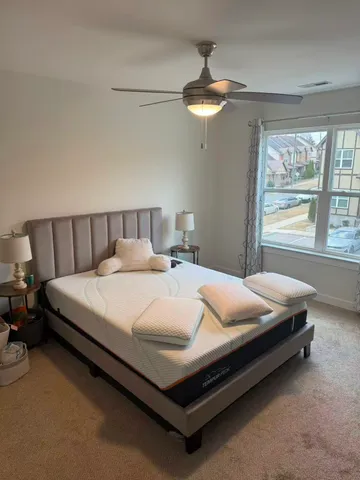 a bed sitting in a bedroom next to a window