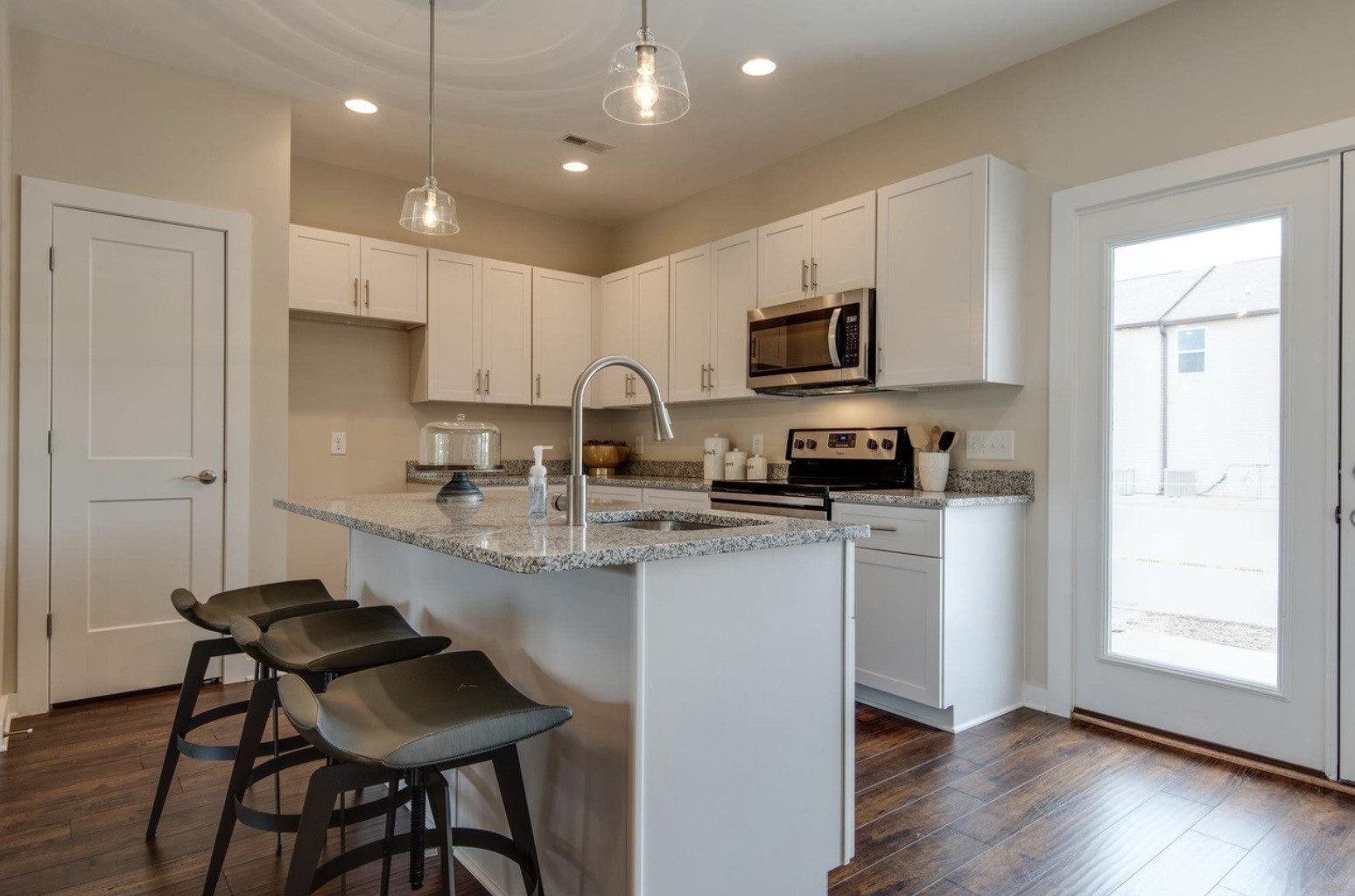 2404 Danilynn Drive Antioch, TN 37013 - Photo 9 of 12 a kitchen with stainless steel appliances granite countertop a stove a sink a microwave a refrigerator and white cabinets with wooden floor